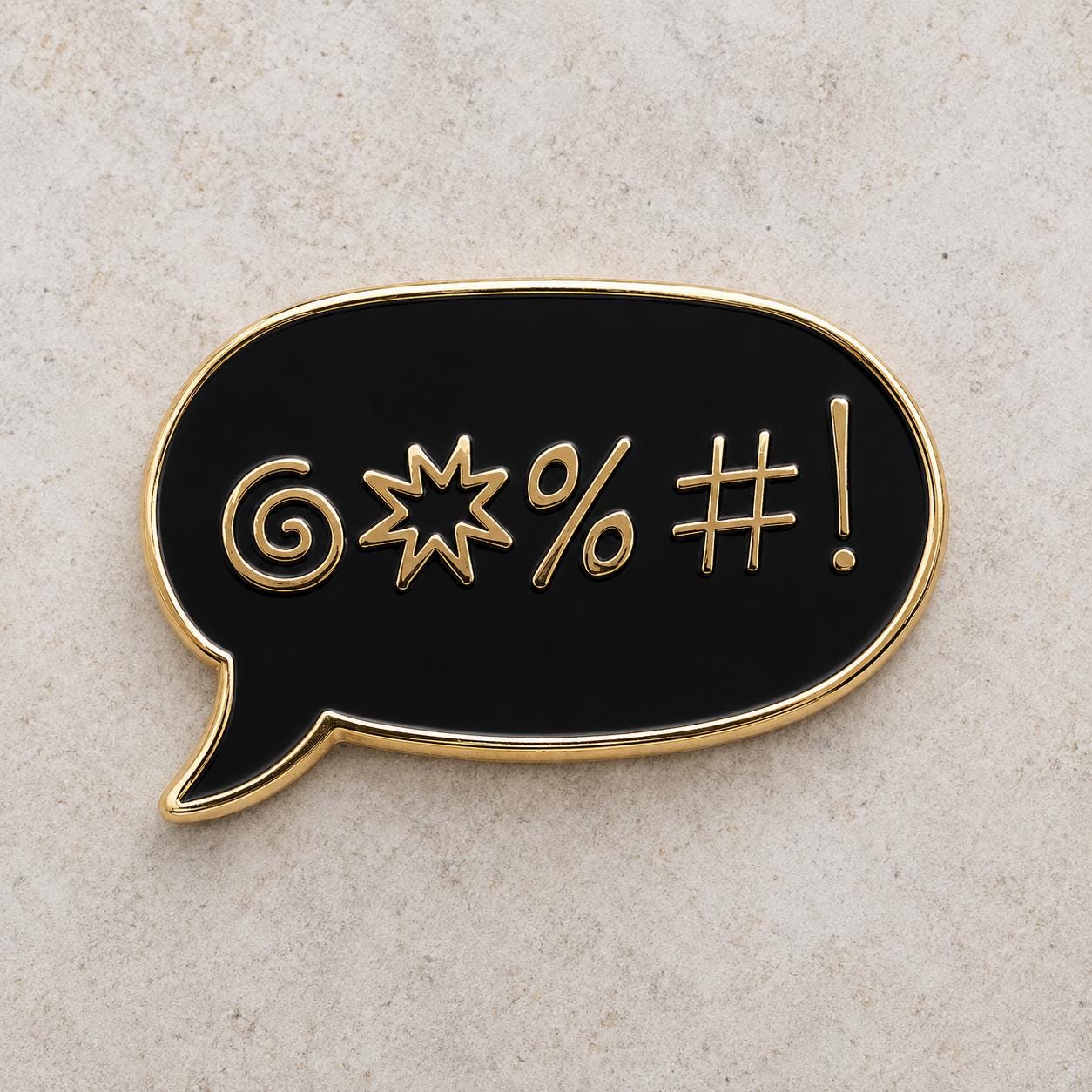 Black sweary enamel pin, gold swear-symbol speech bubble, original design by The Grumpy Unicorn