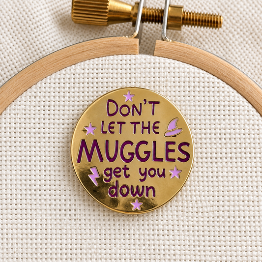 Don't Let the Muggles Get You Down Needle Minder, gold with purple lettering
