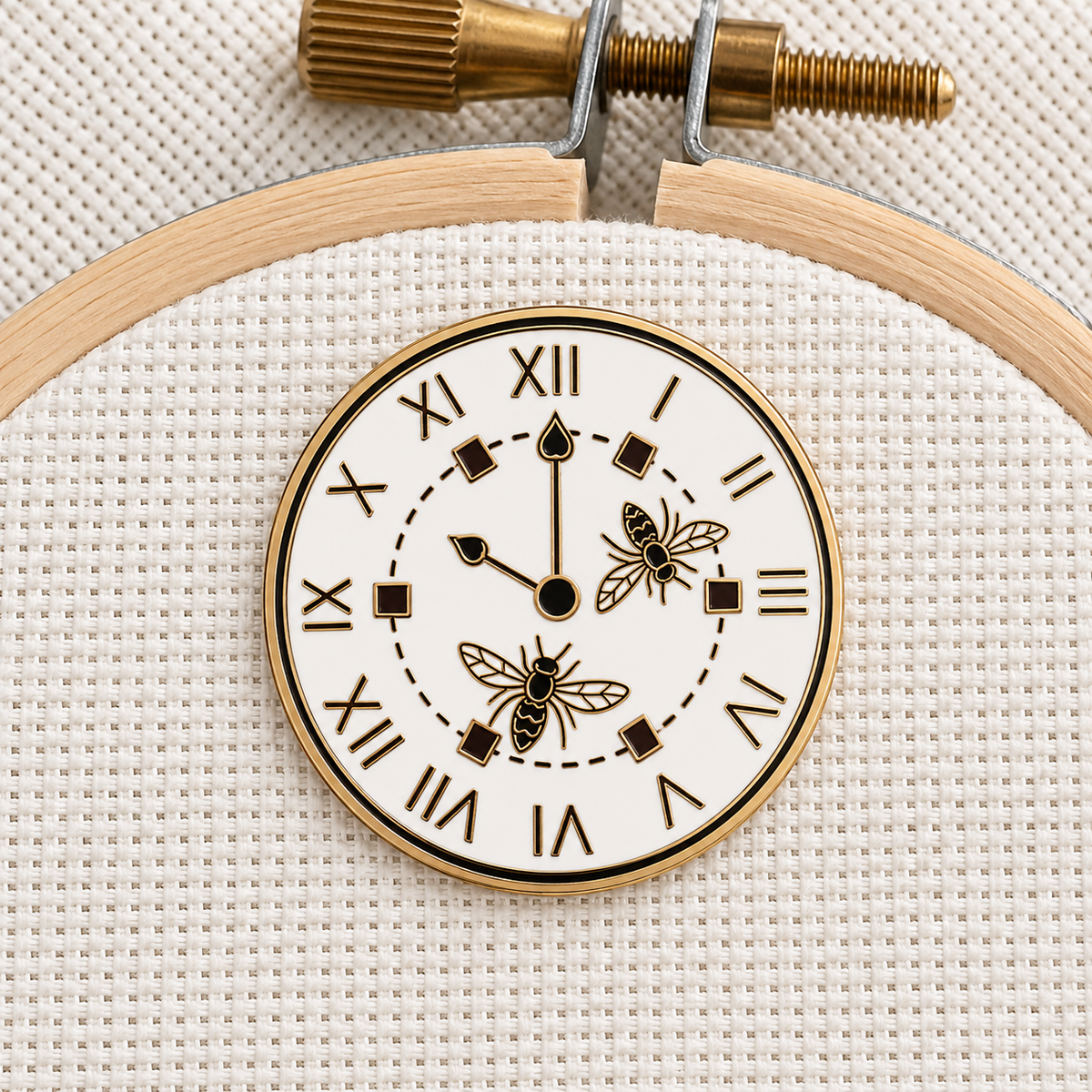 The Wasp Factory Clock Needle Minder on an embroidery hoop, white clock face with two wasps and gold finish