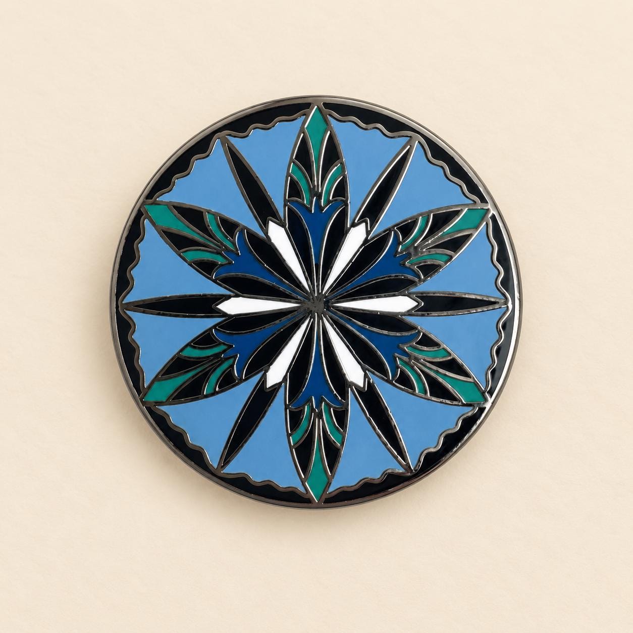 Round elven enamel pin, a twelve point cornflower in navy, teal and white on sky blue