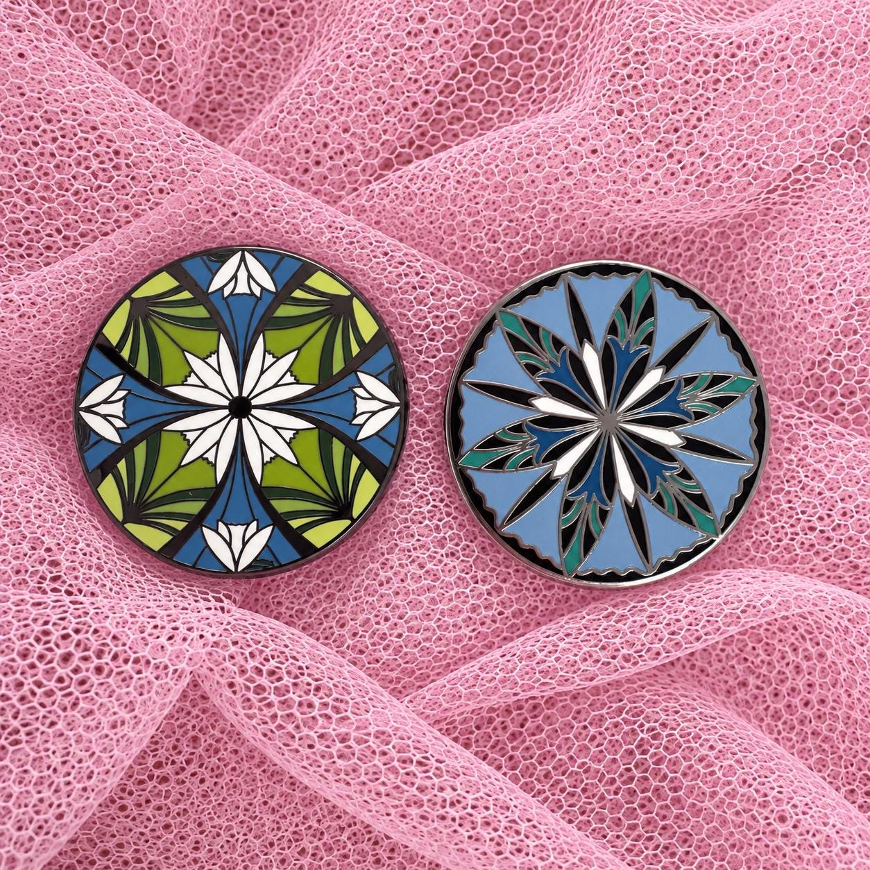 Green and blue elven flower enamel pins on pink tulle fabric