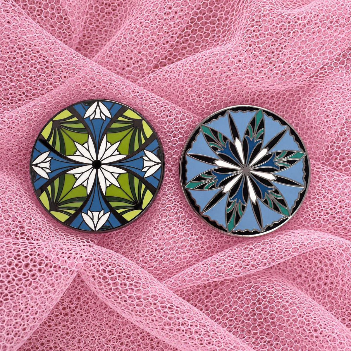 Green and blue elven flower enamel pins on pink tulle fabric