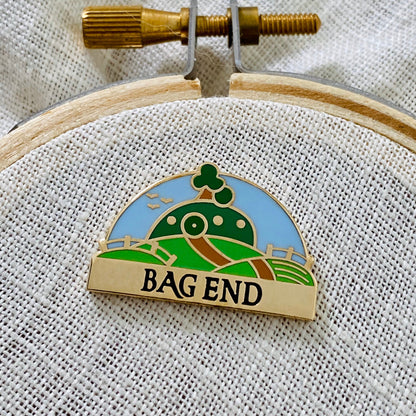 Bag End Needle Minder, gold finish enamel needle minder of Bag End with its name banner