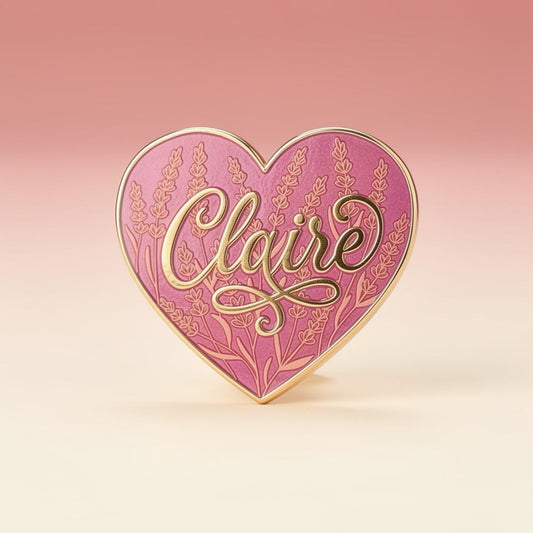 Claire Fraser heart pin — pink heart with lavender stalks engraved into the enamel and Claire in gold script, on a soft pink and cream studio backdrop. Outlander fan pin.