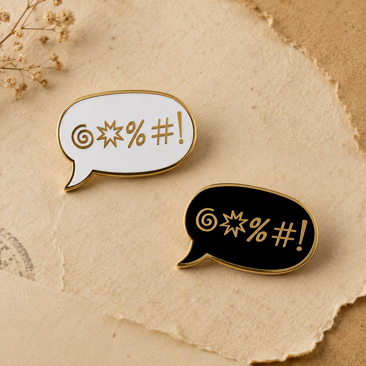 Sweary enamel pin, gold censored-swear symbols in a speech bubble, in white and black hard enamel