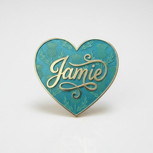 Jamie Fraser heart pin — teal heart with Scottish thistles engraved into the enamel and Jamie in gold script, on a clean white background. Outlander fan pin.